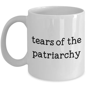May include: White ceramic coffee mug with black text that reads "tears of the patriarchy".