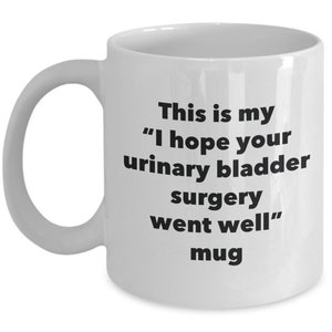 Może przedstawiać: Biały kubek ceramiczny z czarnym tekstem, który brzmi: "This is my "I hope your urinary bladder surgery went well" mug"