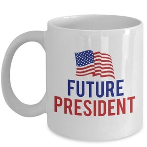 Op de afbeelding: Witte keramische koffiemok met een rood-wit-blauwe Amerikaanse vlag en de tekst "FUTURE PRESIDENT" in rood.