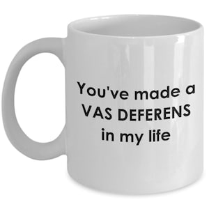 May include: White ceramic coffee mug with black text that reads "You've made a VAS DEFERENS in my life."