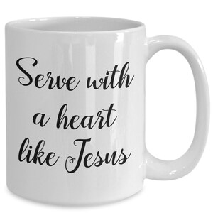 May include: White ceramic coffee mug with black text that reads "Serve with a heart like Jesus".