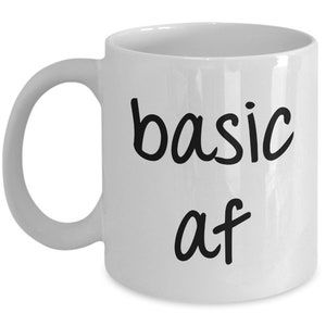 Peut inclure: Une tasse à café en céramique blanche avec du texte noir qui dit "basic af".
