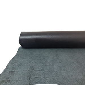 Puede incluir: Un rollo de cuero gris oscuro con un acabado liso y pulido. El cuero est&aacute; enrollado y el extremo es visible.