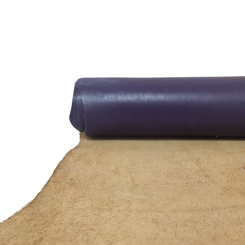 Puede incluir: Un rollo de cuero morado con un respaldo de gamuza marr&oacute;n.