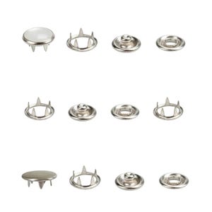 May include: A collection of silver-colored snap fasteners, displayed against a white background. The fasteners include various components: cap, socket, and pronged parts. These are commonly used in sewing and crafting projects.