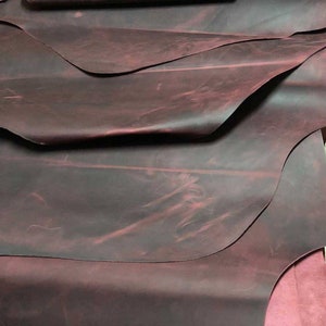 May include: A stack of dark red leather hides with a mottled, distressed finish.