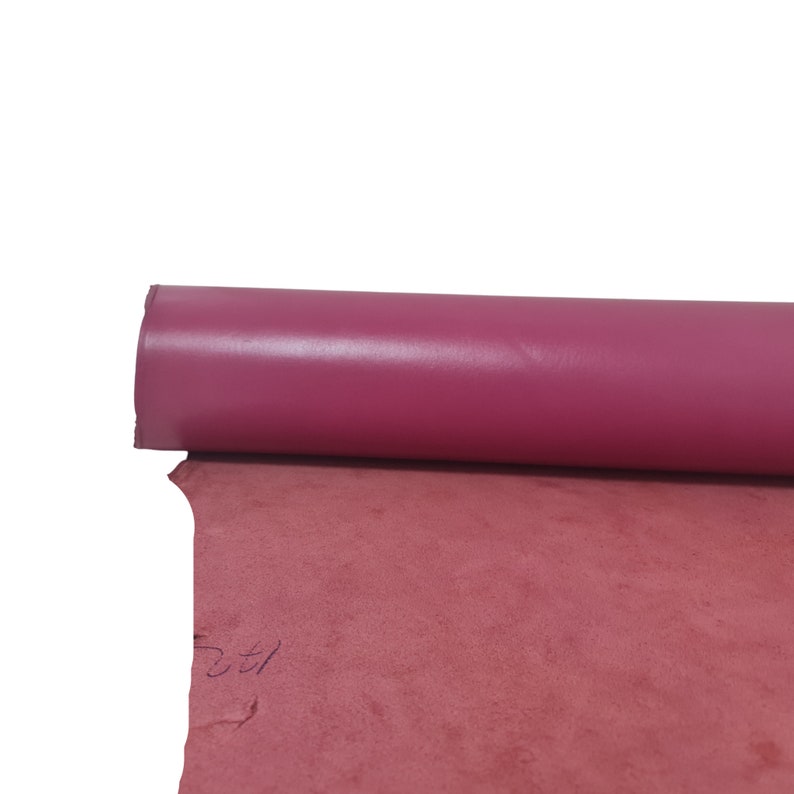 Puede incluir: Un rollo de cuero rosa con un acabado liso y brillante. El cuero est&aacute; enrollado y el extremo es visible.