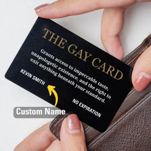 May include: A black card with gold text that reads "THE GAY CARD". The card grants access to impeccable taste and the right to exit anything beneath your standard. Includes the name "KEVIN SMITH" and "Custom Name".