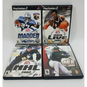Puede incluir: Cuatro cajas de juegos de video para PlayStation 2. Las cajas son azules y negras con texto blanco. Los juegos son EA Sports Madden NFL 2001, EA Sports NBA Live 2002, EA Sports NHL 2002 y 989 Sports MLB 2005.