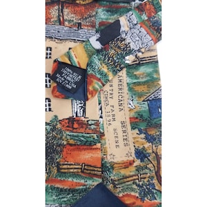 May include: A silk necktie with a colorful Americana farm scene design. The tie features a landscape with a barn, trees, and a fence. The label reads "100% Silk Imported Fabric Made in USA".
