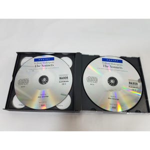 May include: Two compact discs in a black case. The discs are silver with black text, featuring the title "The Sonnets" by William Shakespeare. The discs are labeled "NAXOS AudioBooks" and "CD 2" and "CD 3".