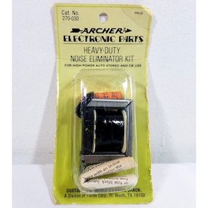 Puede incluir: Un kit eliminador de ruido Heavy-Duty Archer Electronic Parts vintage en un paquete de plástico transparente. El kit incluye un componente negro y plateado con una bobina y un pequeño tubo blanco. El embalaje es amarillo y verde con texto impreso.