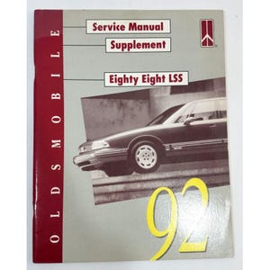 May include: A red and white Oldsmobile service manual supplement for the 1992 Eighty Eight LSS model. The cover features a photo of a silver car.