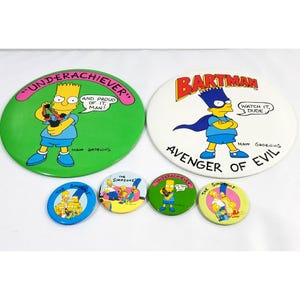 May include: A collection of Simpsons character buttons. The buttons feature Bart Simpson as Bartman and Bart as an underachiever. Other buttons show the Simpsons family. The buttons are round and colorful.