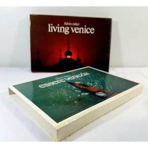 Puede incluir: Dos portadas de libros, una roja con el texto "living venice" y la otra azul con el texto "essere venezia".