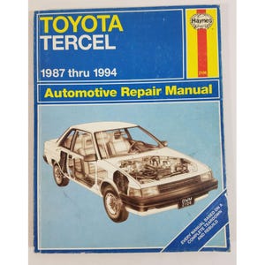 May include: A blue Haynes automotive repair manual for Toyota Tercel models from 1987 thru 1994. The cover features a white line drawing of a car with an exposed engine and interior, along with the text Haynes, Toyota Tercel, and 2106.