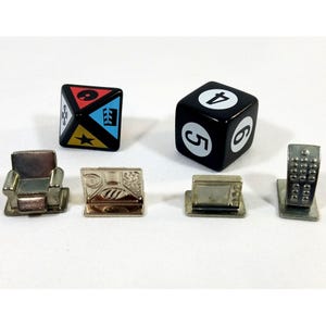 May include: A collection of miniature game pieces, including two dice and four metal tokens. One die is black with white numbers, the other is a multi-colored triangular prism. The tokens depict a chair, a television, a computer, and a telephone.