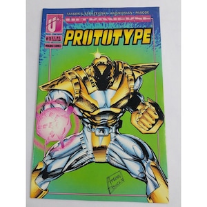 Puede incluir: Una portada de cómic con un personaje de robot metálico, dorado y plateado con una explosión de energía rosa en su mano. El título del cómic es "PROTOTYPE" y el cómic es parte de la serie "ULTRAVERSE".