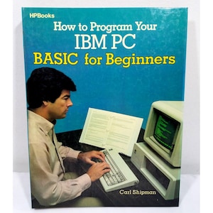 Op de afbeelding: Een vintage boekcover met de titel "How to Program Your IBM PC BASIC for Beginners" op een blauwe achtergrond. De afbeelding toont een man die een computer, een toetsenbord en een monitor gebruikt. De auteur is Carl Shipman.