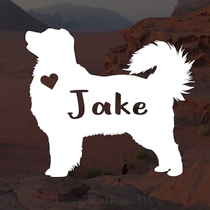Puede incluir: Silueta blanca de un perro con el nombre "Jake" y un corazón encima. El perro está de pie sobre una superficie rocosa marrón.