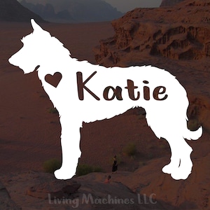 May include: White silhouette of a dog with the name "Katie" and a heart on its chest. The dog is standing on a brown, rocky surface.