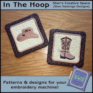 May include: Two embroidered coasters, one with a cowboy hat and the other with a cowboy boot. The coasters are brown with a beige center and are on a wooden surface. The text "In The Hoop by Sher" is visible in the lower right corner of the image.
