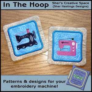 May include: Two embroidered sewing machine designs on beige fabric squares. The designs are in blue and pink with a white background. The text "In The Hoop by Sher" is visible in the lower right corner.