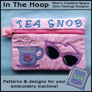 May include: Pink zippered pouch with embroidery of a teacup, sunglasses, and the text "TEA SNOB". The pouch is made for embroidery machines.