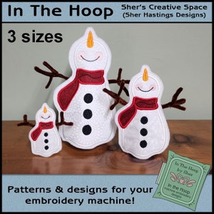 May include: Three embroidered snowman designs in different sizes, with red scarves and black buttons. The designs are for embroidery machines and are available in three sizes. The text "In The Hoop by Sher" is visible in the lower right corner.