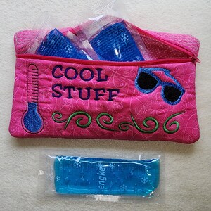 K&ouml;nnte beinhalten: Eine pinkfarbene, gesteppte Tasche mit der Aufschrift "COOL STUFF", einem Thermometer und einer Sonnenbrille. Die Tasche enth&auml;lt blaue K&uuml;hlpacks. Ein einzelnes blaues K&uuml;hlpack liegt davor.