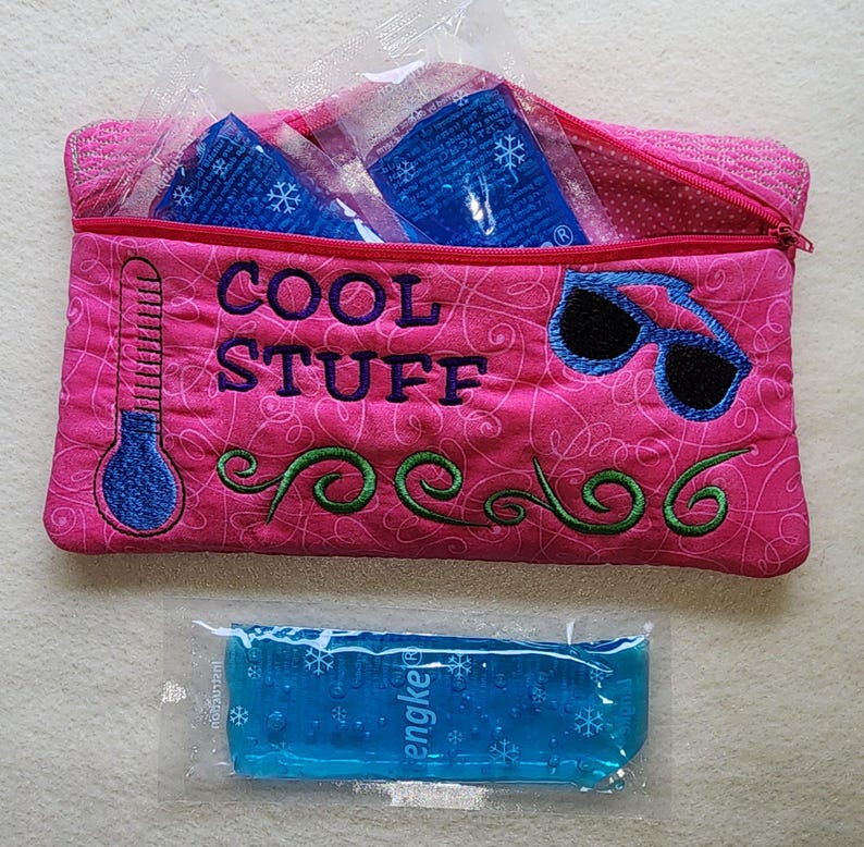 K&ouml;nnte beinhalten: Eine pinkfarbene, gesteppte Tasche mit der Aufschrift "COOL STUFF", einem Thermometer und einer Sonnenbrille. Die Tasche enth&auml;lt blaue K&uuml;hlpacks. Ein einzelnes blaues K&uuml;hlpack liegt davor.