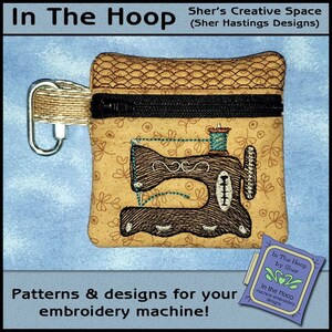 May include: A small, brown zippered pouch with a sewing machine design embroidered on it. The pouch has a metal clasp and is decorated with a floral pattern. The text "In The Hoop by Sher" is visible on a small tag attached to the pouch.