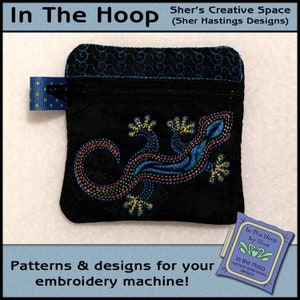 Könnte beinhalten: Eine schwarze Reißverschlusstasche mit einem bunten gestickten Eidechsen-Design. Die Tasche ist mit "In The Hoop by Sher" und "In the Hoop machine embroidery designs" beschriftet.