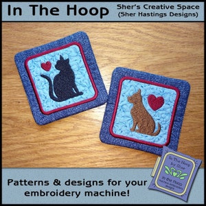 May include: Two embroidered coasters, one with a cat and a heart, and the other with a dog and a heart. The coasters are on a wooden surface. The text "In The Hoop by Sher" is visible in the lower right corner of the image.