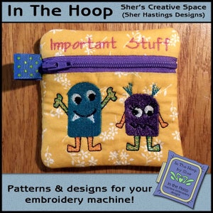 May include: A yellow zippered pouch with the text "Important Stuff" embroidered on the front. The pouch features two embroidered cartoon monsters, one blue and one purple, with the text "In The Hoop by Sher" on a purple tag.