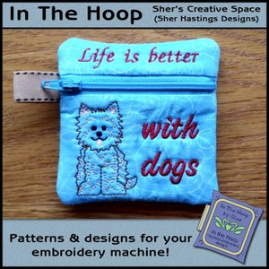 Può includere: Una pochette blu con cerniera con un disegno di un cane e il testo "Life is better with dogs". La pochette è realizzata per macchine da ricamo.