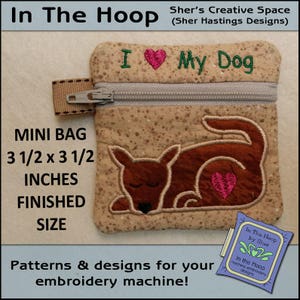 Peut inclure: Un petit sac brun et beige avec une fermeture éclair. Le sac est décoré d'une image brodée d'un chien endormi avec un cœur sur la poitrine. Le texte "J'aime mon chien" est brodé sur le dessus du sac. Le sac mesure 3,5 pouces par 3,5 pouces.