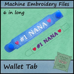 May include: A blue wallet tab, 6 inches long, with the text "#1 NANA" embroidered in white. The tab features a heart design and blue snap closures. The words "Machine Embroidery Files" and "Wallet Tab" are also visible.