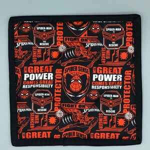 Puede incluir: Salvamanteles cuadrado negro y rojo con temática de Spider-Man. El diseño presenta gráficos de Spider-Man, las palabras "Spider-Man", "Great Power Comes Great Responsibility" y "Fight On". El salvamanteles tiene un borde negro.