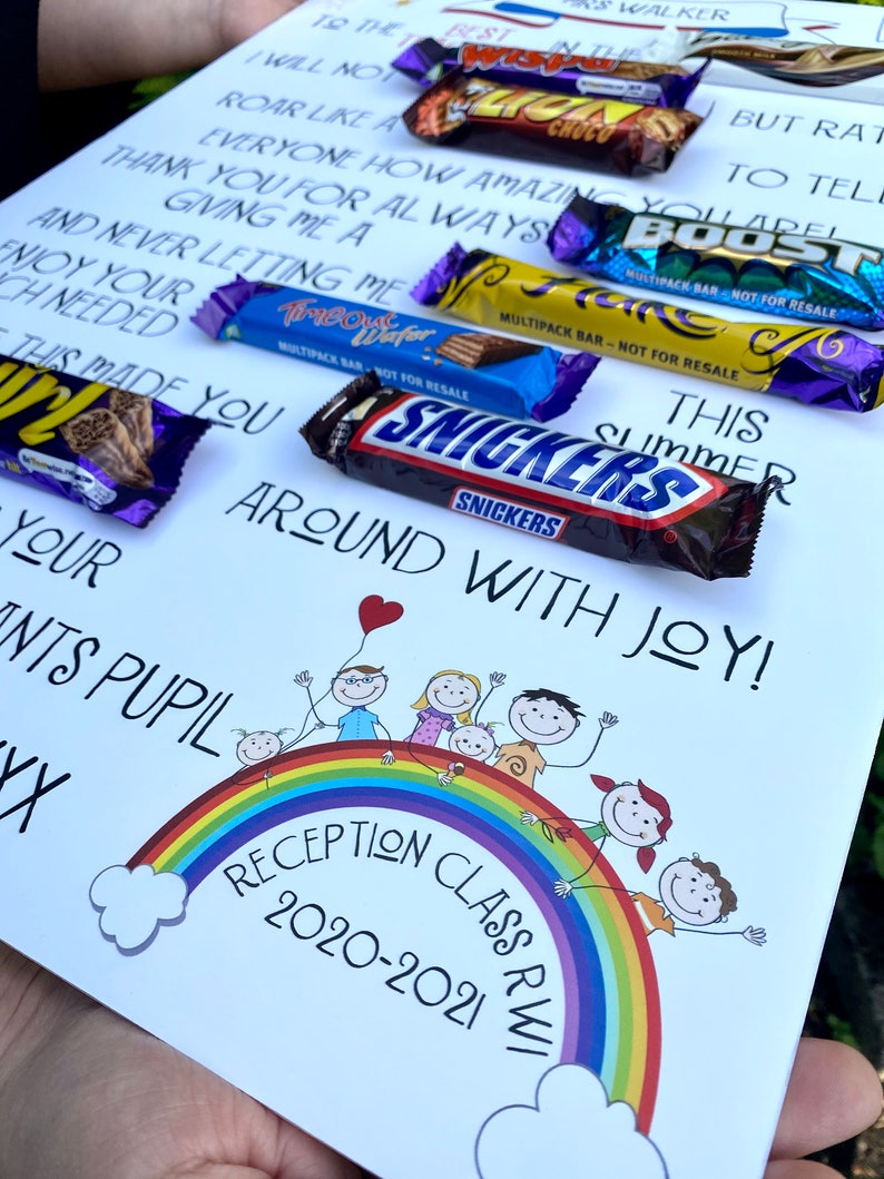 K&ouml;nnte beinhalten: Eine wei&szlig;e Karte mit handschriftlichem Text und Illustrationen, darunter ein Regenbogen und Strichm&auml;nnchen. Mehrere Schokoriegel sind auf der Karte angeordnet. Der Text lautet "Reception Class 2020-2021".