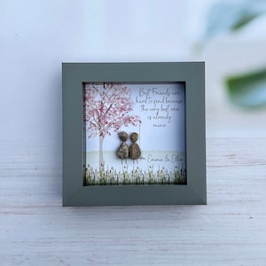 May include: A framed print with a watercolor illustration of two figures sitting on a swing under a tree. The text reads "Best Friends are hard to find because The very best one is already mine" and is signed "Emma & Ellie".