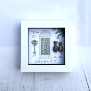Puede incluir: Una imagen enmarcada en blanco con una ilustraci&oacute;n pintada a mano de una puerta verde con el n&uacute;mero de casa "12" y la direcci&oacute;n "12 Elmer Close". Dos personas de guijarros se paran frente a la puerta con el texto "Dave & Claire" debajo. El texto "Our New Home 2024" est&aacute; en la parte inferior de la imagen.