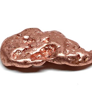 May include: A raw copper nugget with a metallic, reddish-brown luster. The surface is irregular and textured, featuring small pits, crevices, and raised areas that catch the light, creating a natural, unrefined appearance.