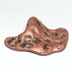 May include: A raw copper nugget with an irregular, flattened shape. The surface displays a metallic, reddish-brown luster with deep, dark, textured crevices and natural indentations across its uneven, organic form.