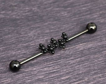 May include: Black industrial barbell with a cluster of small black beads in the center.