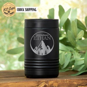 Pu&ograve; includere: Frigorifero per lattine in acciaio inox nero con un design di montagna e alberi. Il testo "GROOMSMAN ETHAN" &egrave; inciso sul frigorifero.