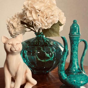 May include: A set of three ceramic mugs with a speckled, matte finish. The mugs are in shades of cream, light gray, and dark gray. Each mug has a simple, minimalist design and a rounded handle. Perfect for coffee or tea.