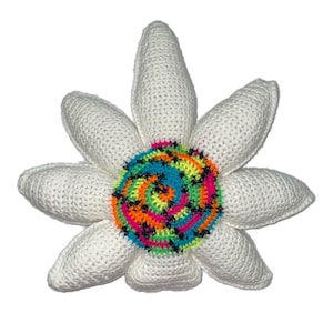 Può includere: Un cuscino a forma di fiore bianco all'uncinetto con un centro a spirale colorato. Il centro è fatto di filati di diversi colori, tra cui rosa, arancio, giallo, verde, blu e nero.
