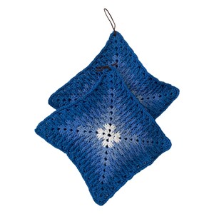 May include: Two square, handmade crochet potholders in shades of blue, with a white floral center design. Each potholder has a loop for hanging. The crochet pattern creates a textured appearance, perfect for kitchen use.