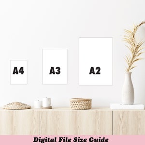 May include: A wall-mounted display of three white rectangular frames labeled A4, A3, and A2, showcasing digital file sizes. The frames are arranged on a white wall above a wooden cabinet. A vase with dried plants is on the right.